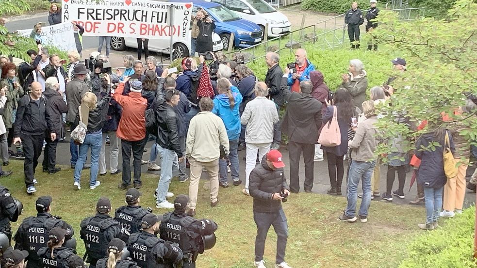 Sucharit Bhakdi wird mit frenetischem Applaus von seinen Unterstützern vorm Plöner Amtsgericht empfangen. Sie stehen Spalier für den Angeklagten. Foto: Eckard Gehm
