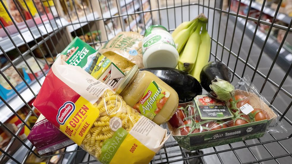 Verschiedene Lebensmittel liegen in einem Supermarkt in einem Einkaufswagen. Foto: DPA