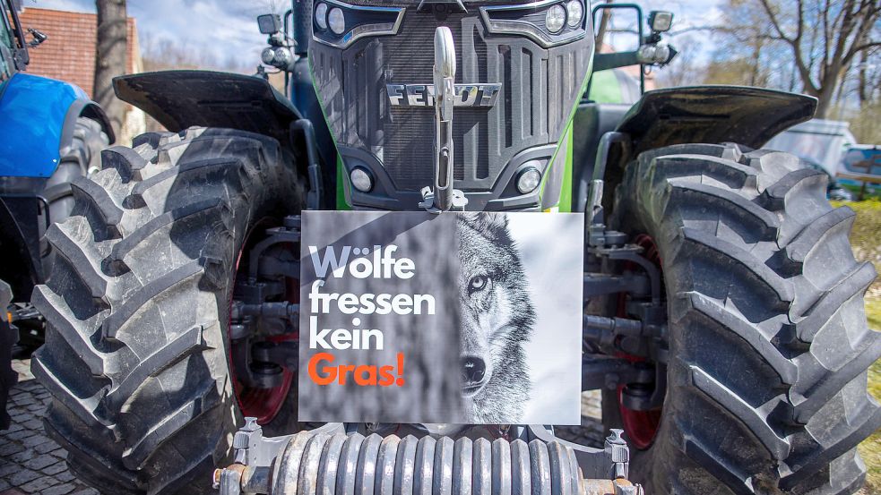 Ein Protestplakat gegen den Wolf steht im April 2021 bei einer Protestaktion von Bauern gegen die weitere Ausbreitung wilder Wölfe auf einem Traktor in Schwerin. Zur Demonstration in Aurich werden am Sonnabend 300 Trecker erwartet. Foto: DPA