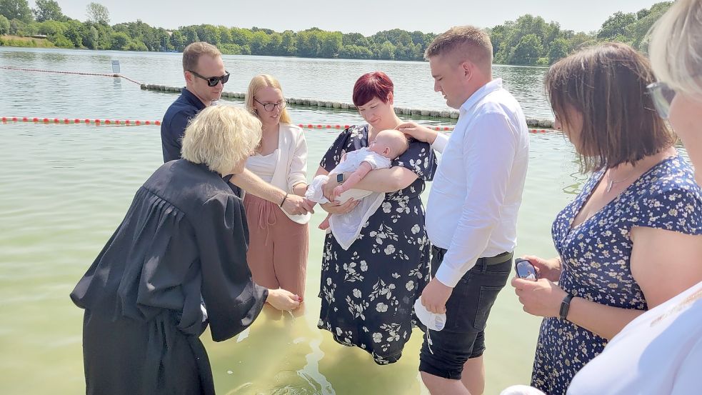 Andreas Fischer, Anke Schoolmann, mit den Taufpaten Bianca Fischer-Oldendörp und Christian Barkhoff sowie der drei Monate alten Amelie Fischer, die von Cathrin Meenken getauft wird.