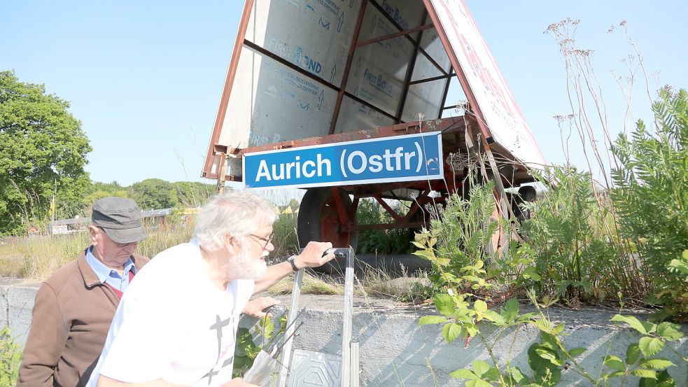 Helmut Wendt (rechts) und seine Mitstreiter brachten ein symbolisches Bahnhofsschild an. Foto: Romuald Banik