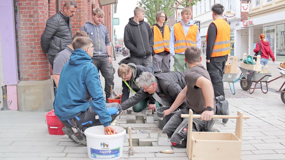 Am Dienstagvormittag begannen Schüler der Auricher BBS II mit der Wiederverlegung der Stolpersteine in der Osterstraße. Foto: Heino Hermanns