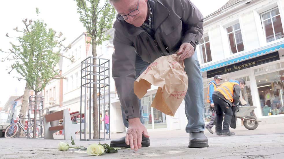 Günther Lübbers, Leiter des Arbeitskreises Stolpersteine, schmückte die neuen Steine mit gelben Rosen. Foto: Heino Hermanns