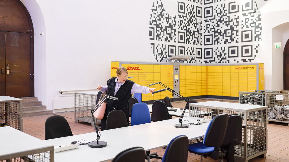 Juliane Schickedanz knipst die Schreibtischlampen an. Aram Bartholls Ausstellung „Ihr Paket ist abholbereit“ ist jetzt in der Kunsthalle Osnabrück zu sehen. Foto: Michael Gründel