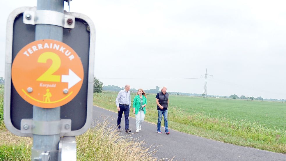 Der Großefehntjer Bürgermeister Erwin Adams (links), Kerstin Fleßner von der Großefehn Tourismus und Wilhelm Buschmann, Vorsitzender des örtlichen Dorfvereins, wandern durch die weiten Felder von Timmel. Foto: Wilfried Frerichs/Großefehn Tourismus