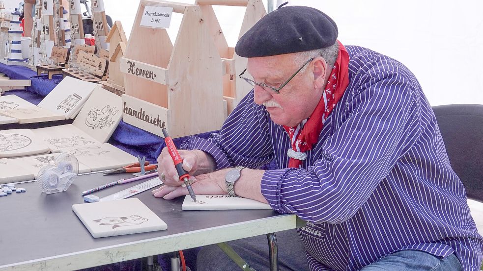 Brandmaler Francisco de Teba, der Küsten-Holzwurm, personalisiert Schilder, Brettchen und Kinderspielzeug aus Holz nach den Wünschen der Kunden. Foto: Helmut Vortanz