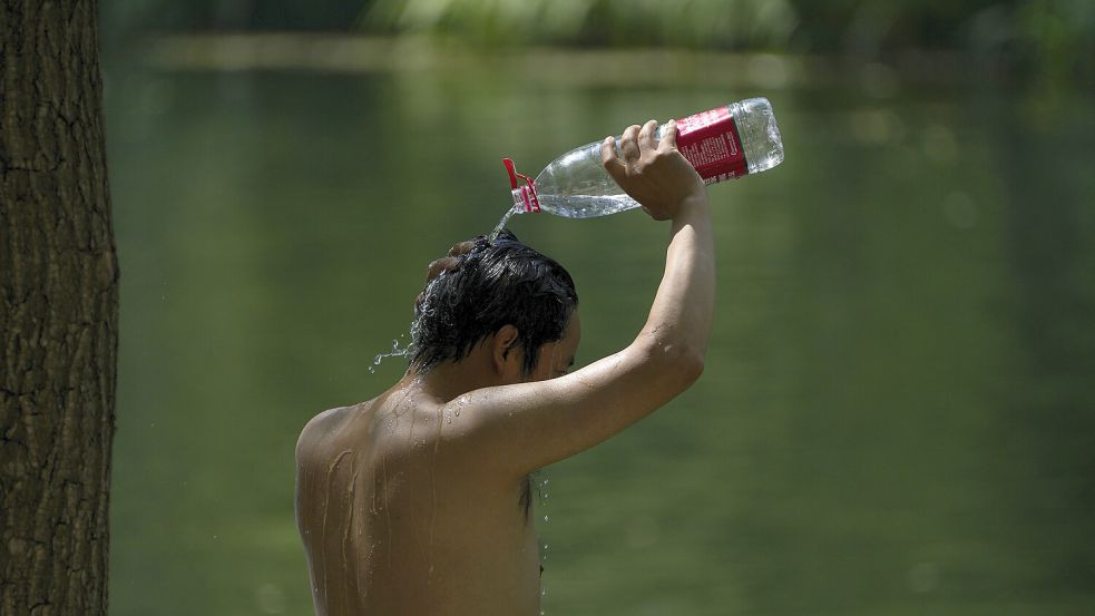 Menschen weltweit leiden unter der momentanen Hitze. Foto: dpa/AP/Andy Wong