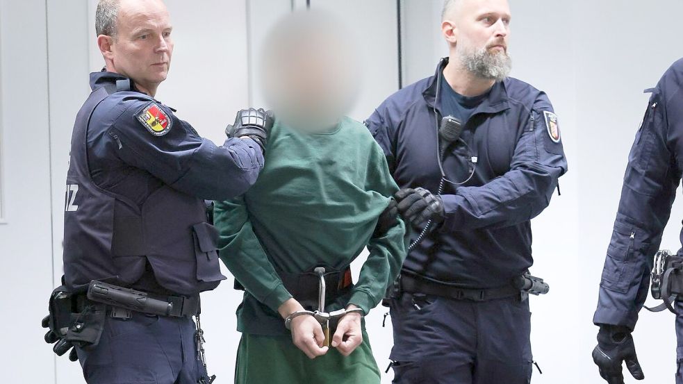 Brokstedt-Prozess um Messerattacke: Der Angeklagte Ibrahim A. unter Begleitung von Justizbeamten im Gerichtssaal. Foto: Christian Charisius/dpa