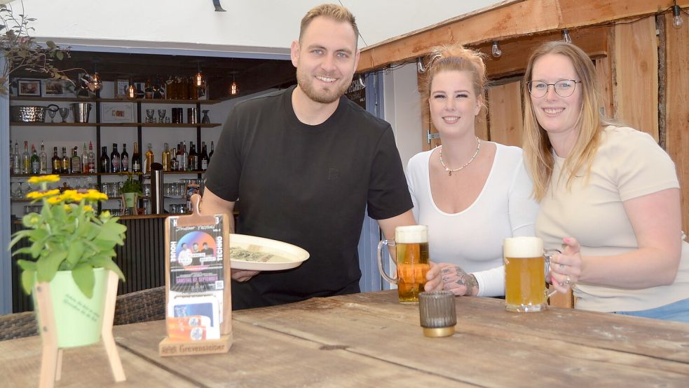 Kattul-Chef Immo Reinders (von links) servierte Saskia Everwien und Jasmin Weberling am Donnerstag Bier. Foto: Neelke Harms