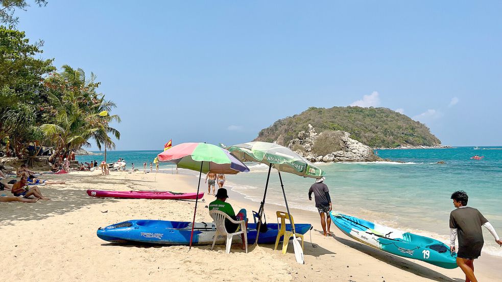 Ein Mann an einem Strand in Phuket schützt sich vor der Sonne am Strand. Reisen nach Thailand sind bei den Ostfriesen besonders im hiesigen Winter beliebt. Foto: DPA