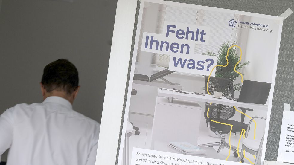 Ein Protestplakat hängt an der Eingangstür einer Hausarztpraxis. Foto: DPA