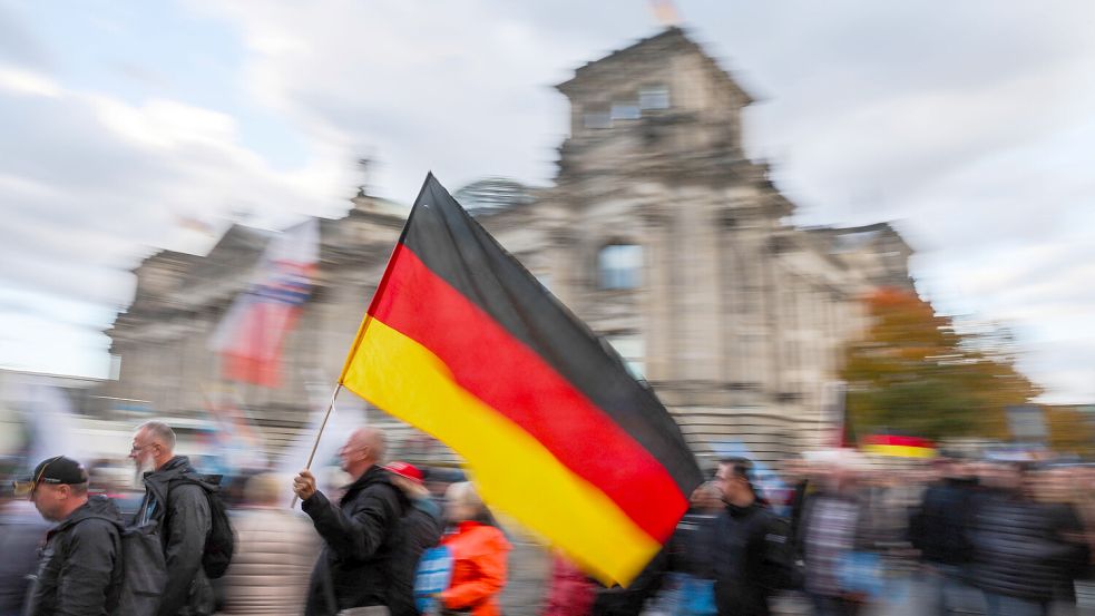Bei einer Demonstration weht die deutsche Flagge vor dem Reichstagsgebäude in Berlin. Umfragen zufolge könnte die AfD eine hohe Prozentzahl bei der nächsten Wahl erreichen. Foto: DPA