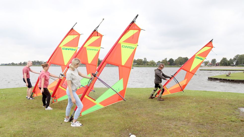 Surflehrer Jens Radde (rechts) bringt seinen Schülern an Land zunächst die Grundlagen und das Gefühl für das Segel bei. Foto: Karin Böhmer