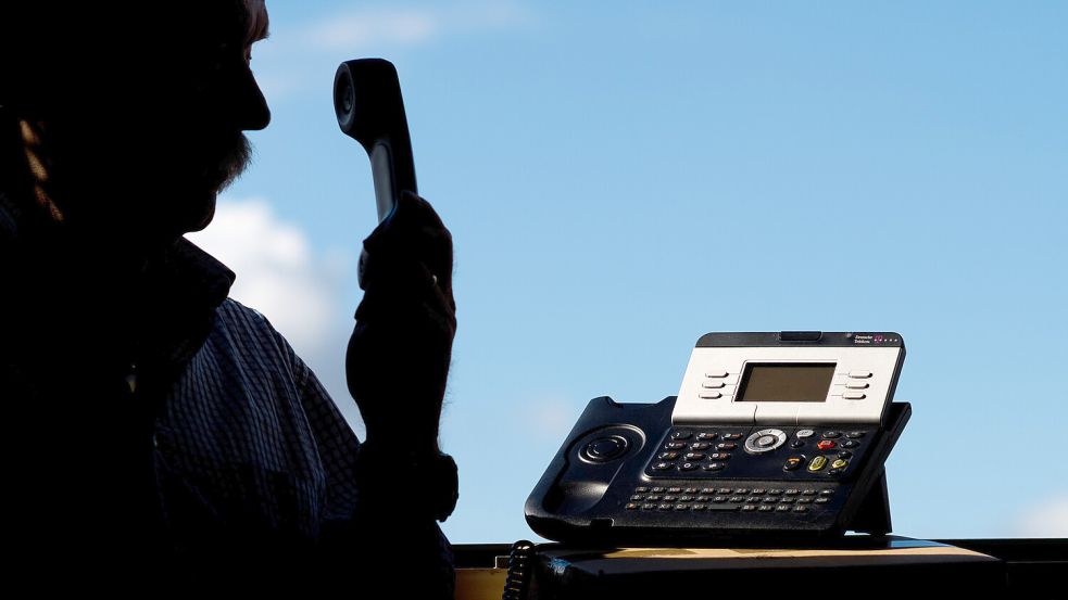 Ein Mann hält in dieser gestellten Szene ein Telefon. Immer wieder werden Menschen Opfer von Trickbetrügern, die sich über das Telefon bei ihnen melden. Foto: DPA