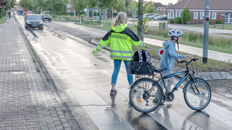 Beschützt von Verkehrshelferin Tina Uphoff quert ein Kind auf dem Weg zur Grundschule die Hauptstraße in Rechtsupweg. Foto: Folkert Bents