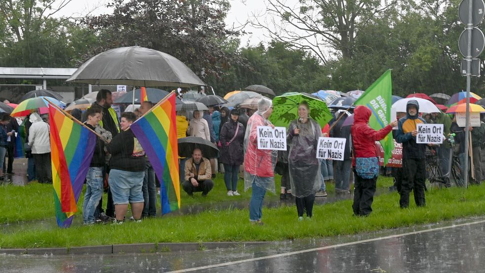 Der Dauerregen konnte den Demonstranten nichts anhaben. Tapfer hielten sie ihre Regenbogenfahnen und Schilder an der Zufahrtsstraße zum Veranstaltungsgelände hoch. Foto: Kim Hüsing