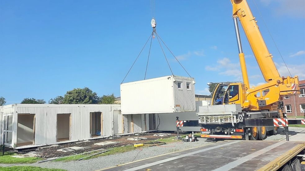 Mit einem Kran werden die Container angehoben und auf Lastwagen verladen. Foto: Frank Süßen