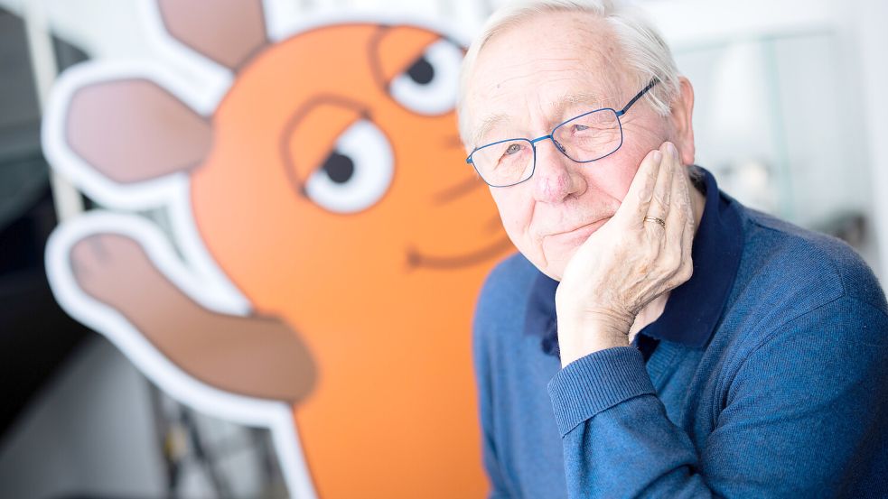 Armin Maiwald (83) und seine berühmte, orangefarbene Maus. Foto: picture alliance/dpa/Rolf Vennenbernd