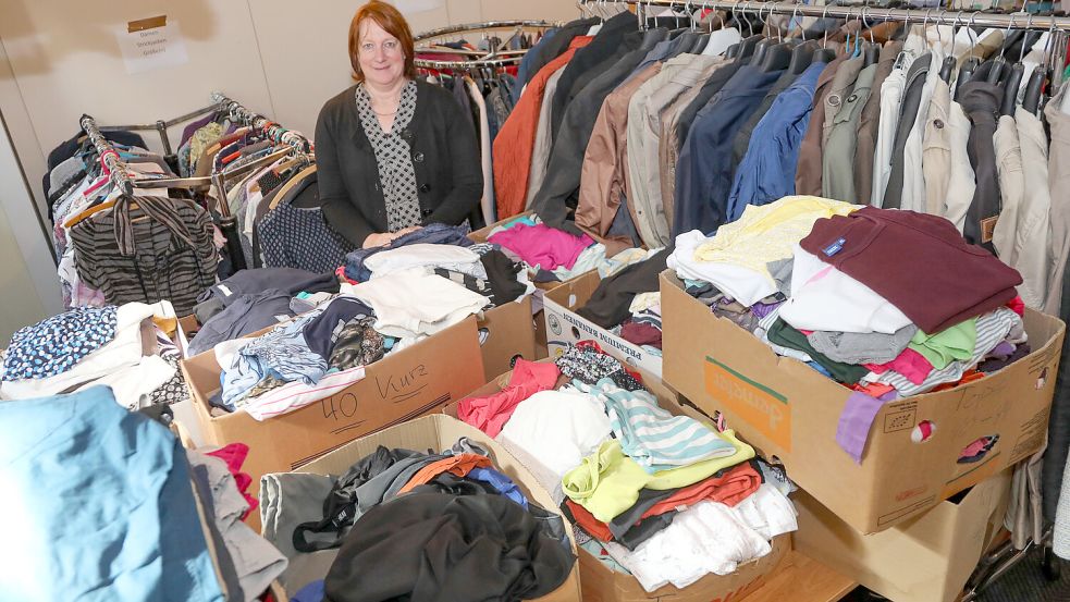 Edelgard Wienekamp von der Kleiderkammer Ihlow steht zwischen den Bergen aus Spenden. Foto: Romuald Banik