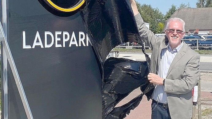 Mit der Enthüllung der Werbetafel eröffnete Rik Folkerts seinen Ladepark in Moordorf. Foto: Holger Janssen