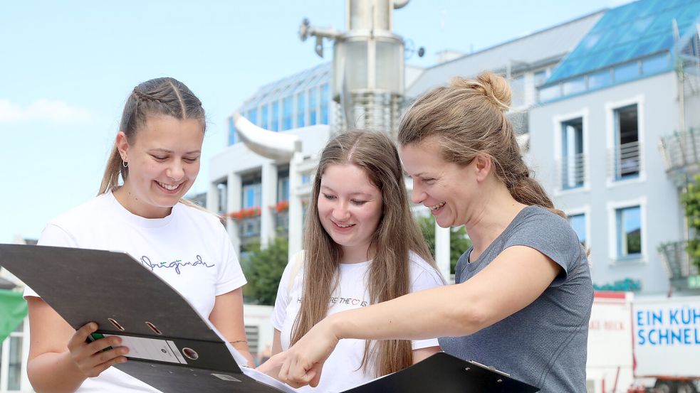 Sandra Pfeiffer-Fecht (rechts) bespricht mit ihren Kolleginnen Stina Büscher und Jule Collmann den Stadtfest-Aufbau auf dem Marktplatz. Foto: Romuald Banik