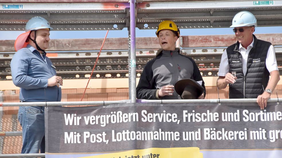 Auf dem Baugerüst hörten sich die Betreiber des neuen Marienhafer E-Centers, Marco (links) und Manfred Kruse (rechts), den Richtspruch eines Handwerkers an. Foto: Thomas Dirks