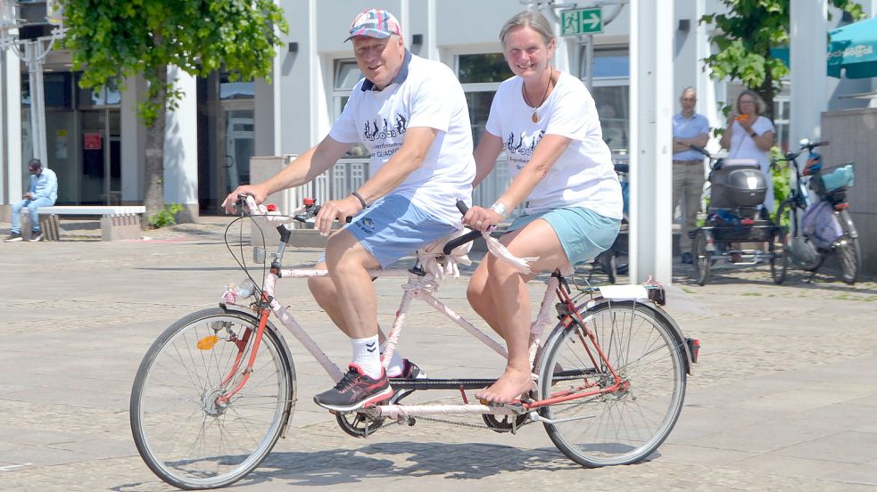 Der Fahrradbeauftragte der Stadt Aurich Frank Patschke fuhr mit Heidrun Weber auf einem Tandem über den Auricher Marktplatz. Foto: Neelke Harms