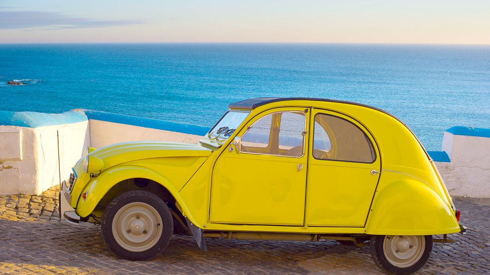 Wie ein Bild vom besseren Leben: Ein Citroen 2 CV, eine Ente, vor dem blauen Meer Frankreichs. Foto: IMAGO/Zoonar
