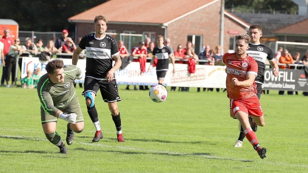 Der Wiesmoorer Torwart Raik de Buhr (links) und der Großefehntjer Angreifer Tom Böhling (rechts) haben den Ball im Visier. Wenige Sekunden später war klar, wer jubilierte. De Buhr griff neben den Ball und Böhling bedankte sich mit seinem Tor zur zwischenzeitlichen 2:0-Führung des SV Großefehn. Foto: Wilfried Gronewold