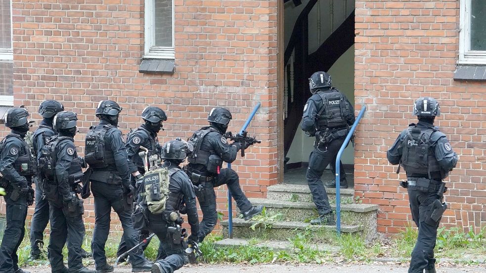 Polizisten stürmen eines der leerstehenden Gebäude auf dem Gelände des ehemaligen Marinefliegergeschwaders MFG 5 in Kiel Holtenau. Foto: Marcus Brandt/dpa