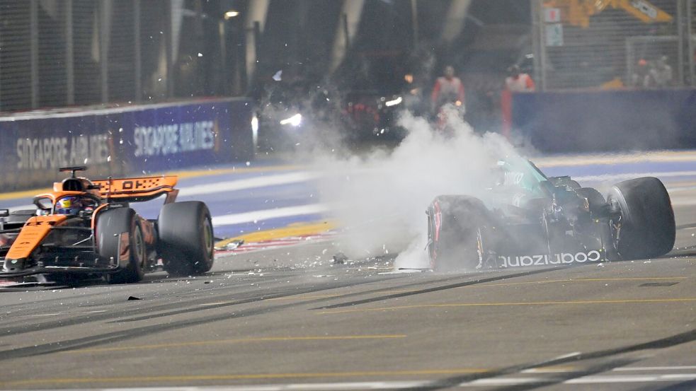Nach einem Unfall steigt aus dem Auto von Lance Stroll (r) Rauch auf, während Oscar Piastri an der Unfallstelle vorbeifährt. Foto: Caroline Chia/Reuters Pool/AP/dpa
