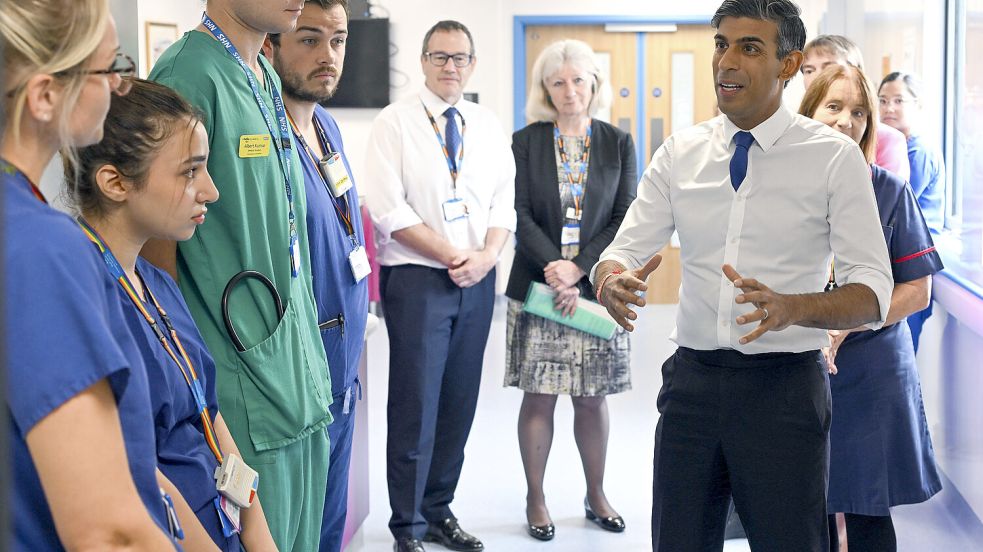 Großbritanniens Premier Rishi Sunak (r.) trifft das Personal des North Devon District Hospitals. Entgegen den Versprechen der britischen Regierung steigen die Wartezeiten in Krankenhäusern weiter an. Foto: dpa/PA/Finbarr Webster