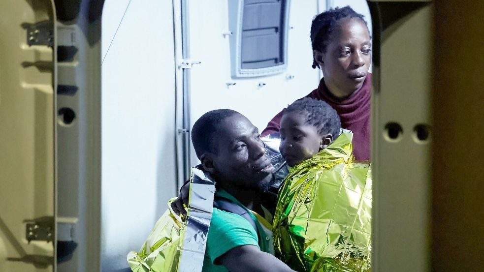 Gerettete Migranten gehen auf der italienischen Insel Lampedusa von einem Boot an Land. Foto: Cecilia Fabiano/LaPresse via AP/dpa