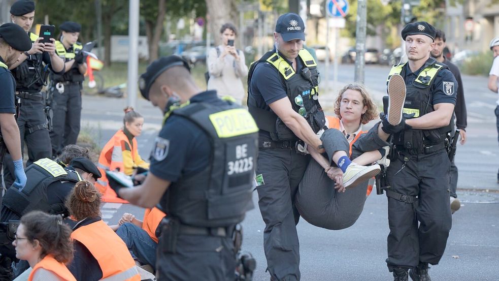 Die Polizei ist mit 500 Beamten im Einsatz. Hier werden Aktivisten der Letzten Generation vom Mehringdamm in Berlin weggetragen. Foto: Sebastian Christoph Gollnow/dpa