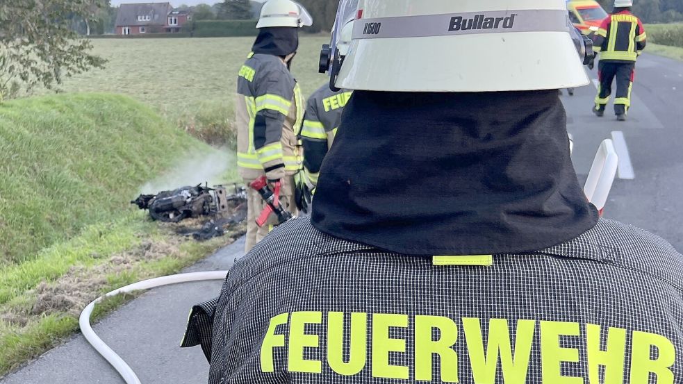 Feuerwehrleute an dem brennenden Fahrzeugwrack. Foto: Pascal Coordes/Feuerwehr Ihlow