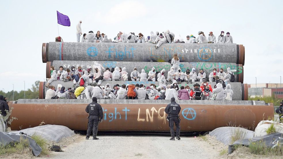 Aktivisten sind am Samstag im Hafen von Mukran auf Rohre geklettert, die für das LNG-Terminal in die Ostsee gelegt werden sollen. Durch die Rohre soll das Gas von Rügen nach Lubmin fließen. Foto: SPM Gruppe/dpa