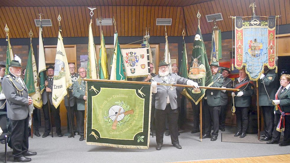 Sven Rump präsentiert die neue Fahne des Auricher Schützenvereins im Kreis der Fahnen benachbarter Vereine. Foto: Gerd-Arnold Ubben