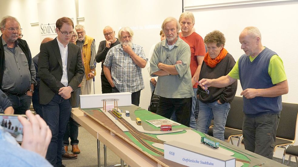 Volkmar Hildebrandt (rechts) präsentiert das Modell einer ostfriesischen Straßenbahn während eines Info-Abends des Aurichern Vereins „Ran an die Bahn“. Foto: Helmut Vortanz