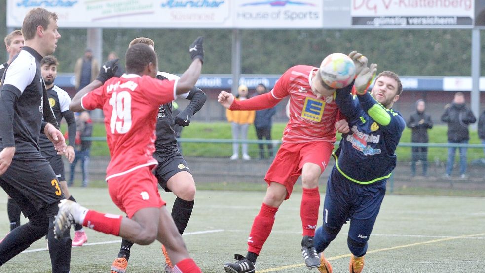 In der vergangenen Saison fand das Derby zwischen Aurich (rote Trikots) und Middels auf dem Kunstrasen am Ellernfeld statt. Am Ende setzten sich die Gäste mit 2:1 durch. In dieser Szene verhinderte der TuS-Torwart Kacper Kempisty (rechts) einen Kopfballtreffer des Aurichers Stanislav Geis. Der Middelser Christoph Wirz (links) und der Auricher Yahya Berete schauten zu. Foto: Bernd Wolfenberg