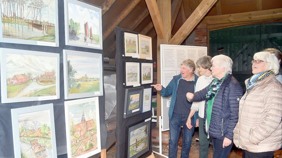 Hobbymaler Gerd Joosten erklärt der Museumsvorsitzenden Kerstin Buss (Zweite von links) und Besucherinnen seine gemalten Bilder. Foto: Gerd-Arnold Ubben