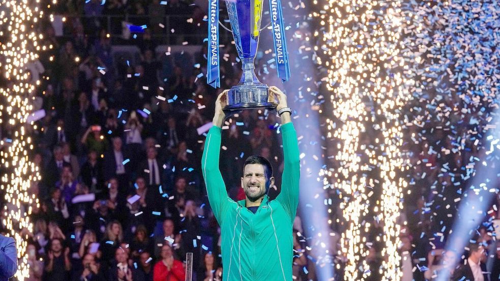 Novak Djokovic jubelt mit seiner Trophäe nach seinem Sieg. Foto: Antonio Calanni/AP/dpa