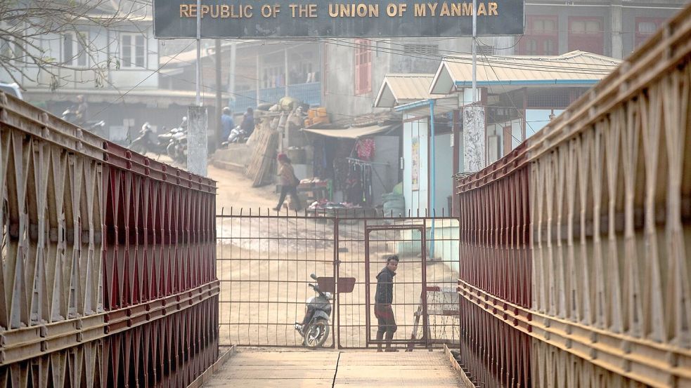 Ein Myanmarese blickt an der Grenze zwischen Indien und Myanmar in Richtung der indischen Seite. Foto: Anupam Nath/AP/dpa