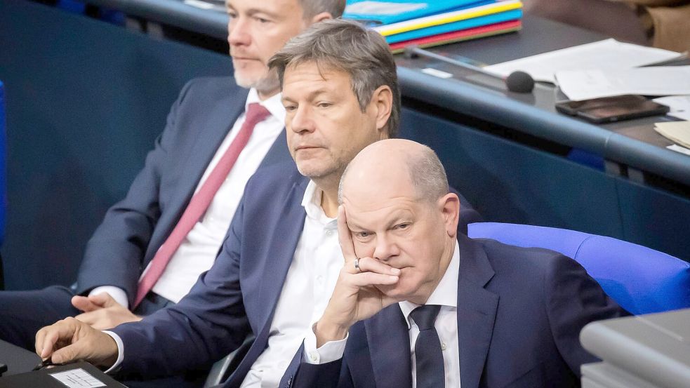 Bundeskanzler Olaf Scholz (SPD, r-l), Wirtschaftsminister Robert Habeck (Bündnis 90/Die Grünen) und Finanzminister Christian Lindner (FDP) verfolgen im Deutschen Bundestag die Debatte. Foto: Christoph Soeder/dpa