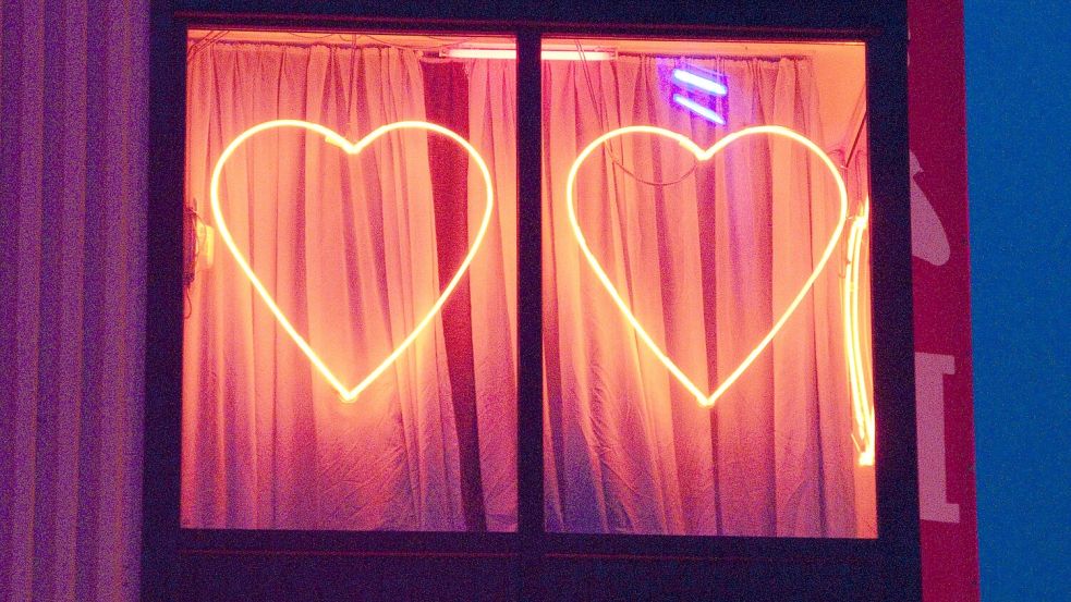 Zwei rot leuchtende Herzen an einem Fenster mit rotem Vorhang. Bei Europas größter Swinger-Party werden bis zu Zehntausend Gäste erwartet. Foto: imago images/imagebroker