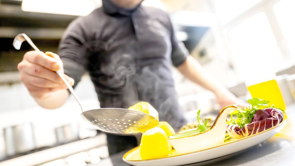 Essen wird in einem Restaurant auf einem Teller angerichtet. Foto: DPA