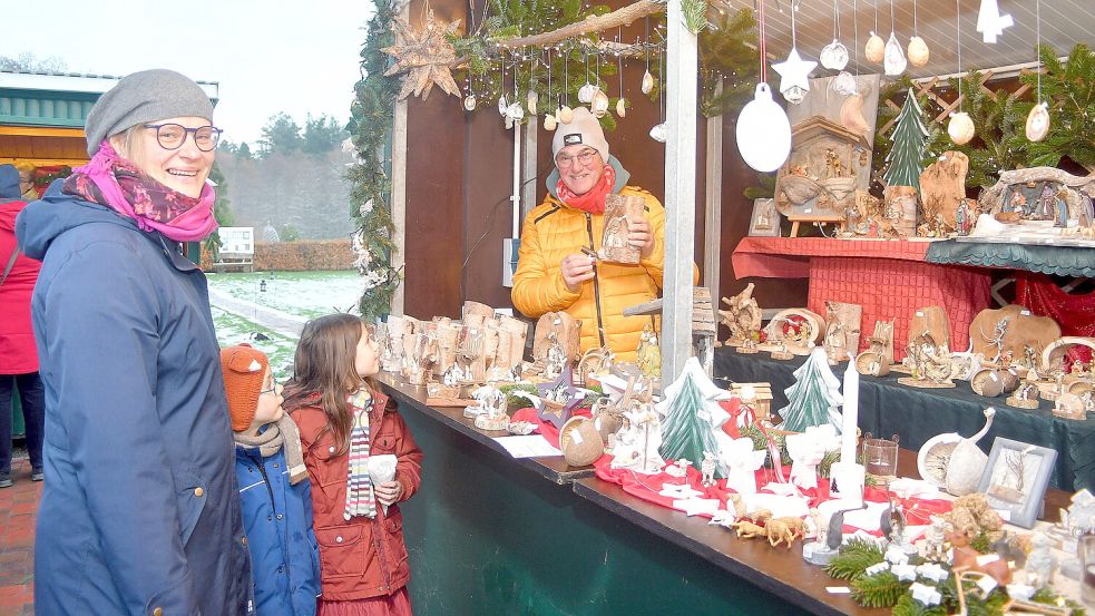 Magdalena Bondar mit ihren Kindern vor dem Verkaufsstand von Hinrich Uphoff aus Neu-Barstede, der weit über die Grenzen Ihlows hinaus bekannte Krippenbauer. Foto: Gerd-Arnold Ubben