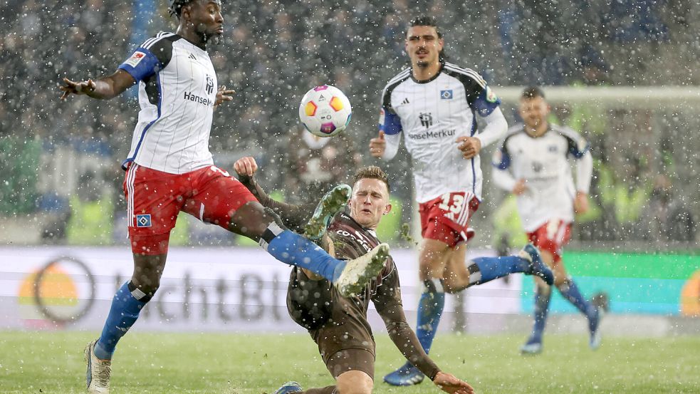 Harter Zweikampf im Schneetreiben: Johannes Eggestein (FC St. Pauli, re.) grätscht gegen HSV-Verteidiger Stephan Ambrosius. Foto: imago images / osnapix