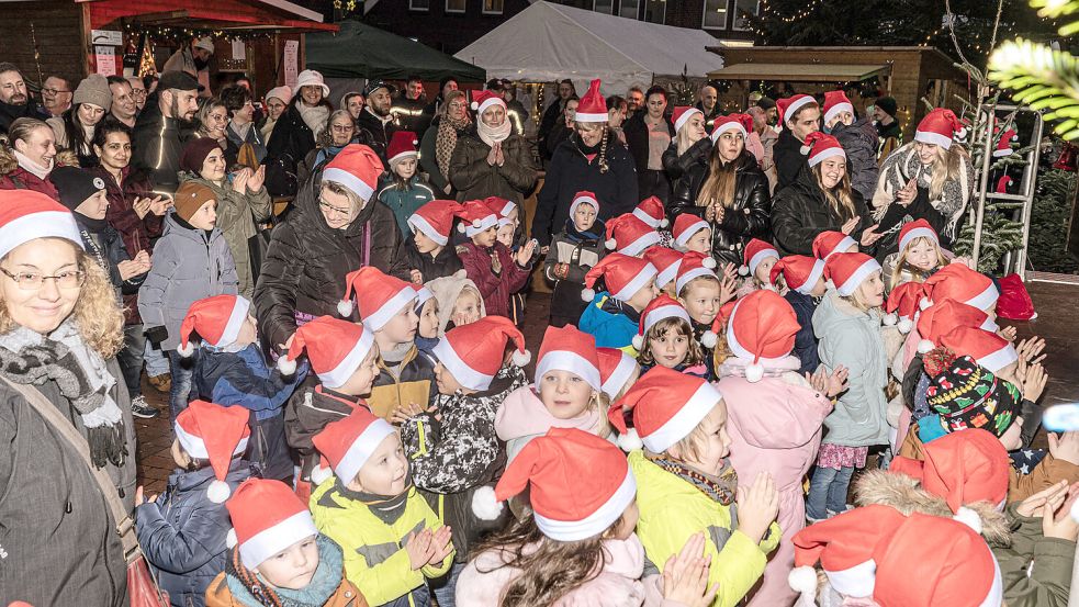 Kinder aus dem Marienhafer Kindergarten sangen bei der Eröffnung des Weihnachtsmarktes Lieder. Foto: Folkert Bents