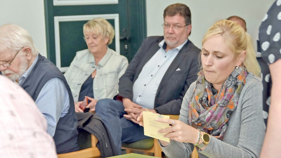 Beobachtet vom alten und neuen Brookmerlander Samtgemeindebürgermeister Gerhard Ihmels (SPD, im Hintergrund) begutachtet Wahlausschussmitglied Rieke Klaassen einen der ungültigen Stimmzettel der Stichwahl vom Sonntag. Foto: Thomas Dirks