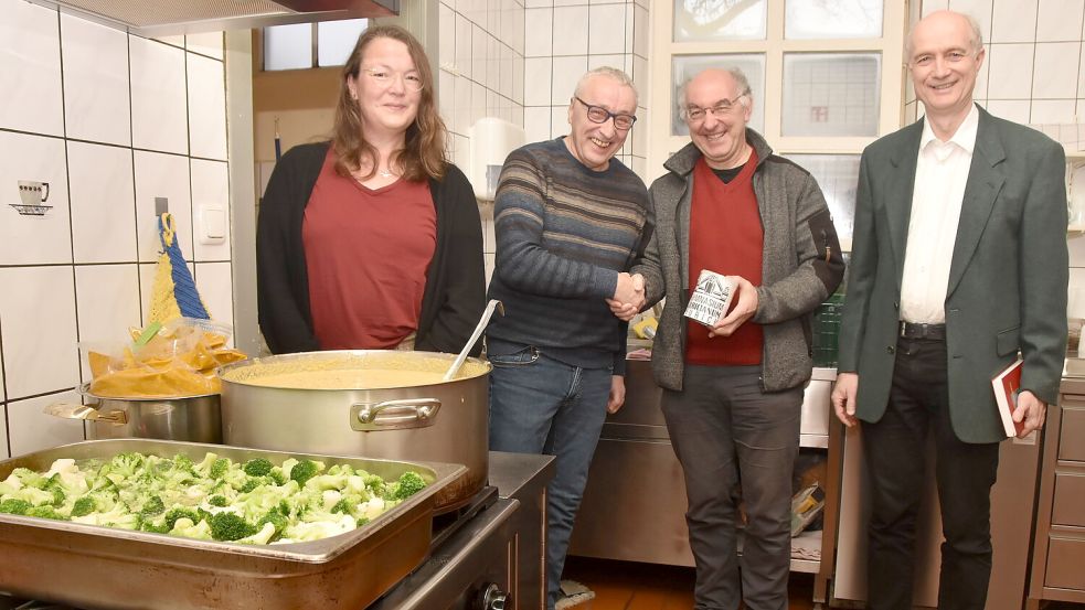 Spendenübergabe am Kochtopf: Musiklehrer Christoph Beyer (Zweiter von rechts) überreichte eine Spendendose mit 878 Euro an den Leiter des Tagesaufenthalts, Thomas Raehse. Dessen Kollegin Ute Onken und Pastor Jörg Schmid freuten sich mit ihm. Foto: Thomas Dirks